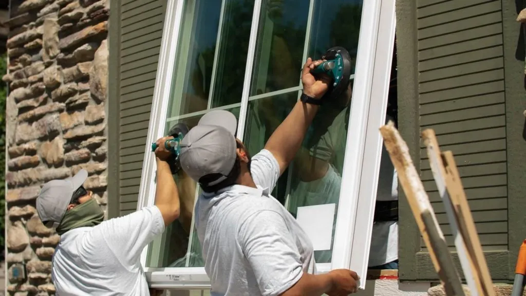Clearwater Exteriors Employees installing double-hung window